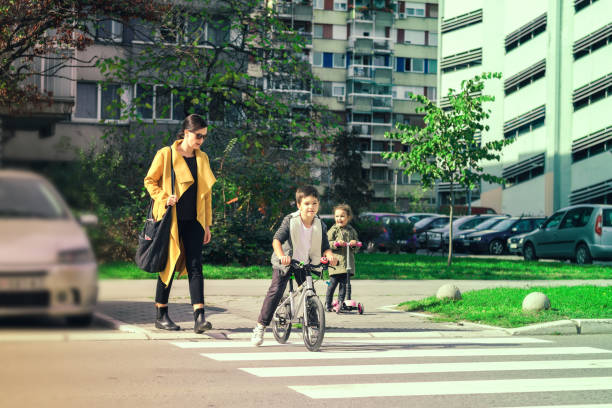 madre y niños cruzando la calle. - familia de cruzar la calle fotografías e imágenes de stock