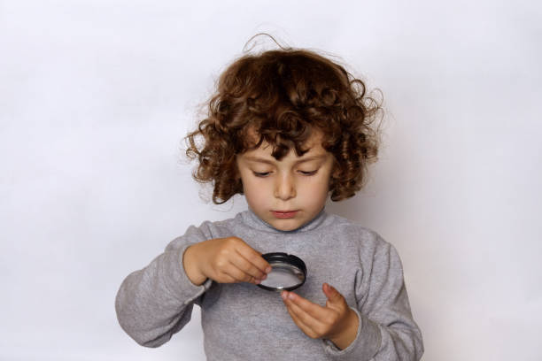 little girl studying her fingers through the magnifying lens - magnifying glass lens holding europe imagens e fotografias de stock