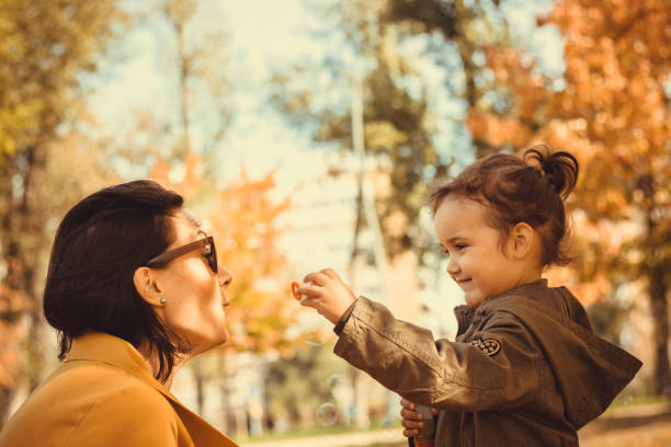 istock Happy mother and daughter blowing bubbles in the park. 896190464