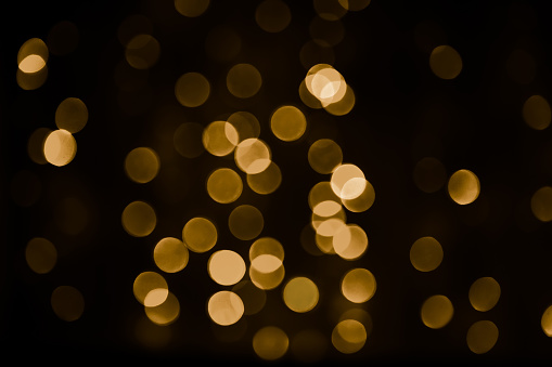 Beautiful Overlay bokeh light texture for design. Golden spot light scattered on black background. Holiday disco pattern for backdrop. Can use for decoration Festive cards, banners, flyers