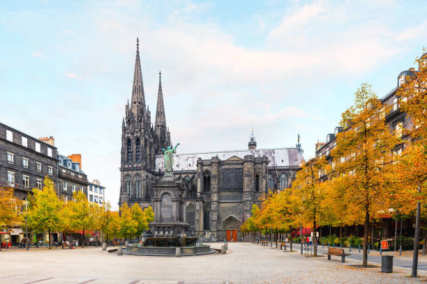Clermont-Ferrand, France - October 01, 2017: View from old city centre of the Clermont-Ferrand with famous Gothic Cathedral Notre Dame in France in autumn. There are cafes and restaurants around cathedral. The cathedral constructed from black lava rocks, Construction began in 1248. Clermont-Ferrand cathedral is very famous gothic cathedral in France.