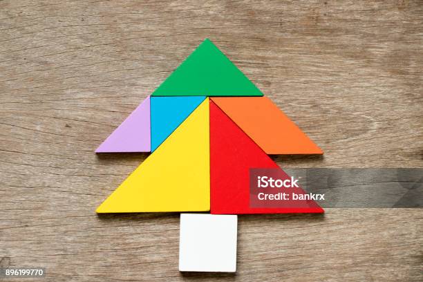 Colorful Tangram Puzzle In Pine Or Christmas Tree Shape On Wood Background Stock Photo - Download Image Now