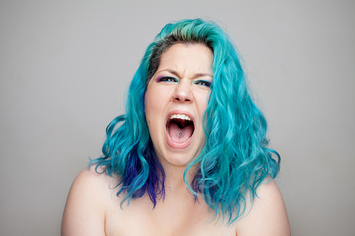 Young woman shouting, mouth wide open