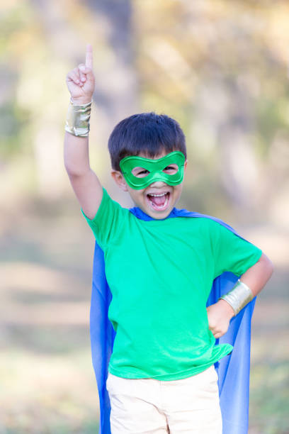 istock Little boy poses in superhero costume outside 896216636