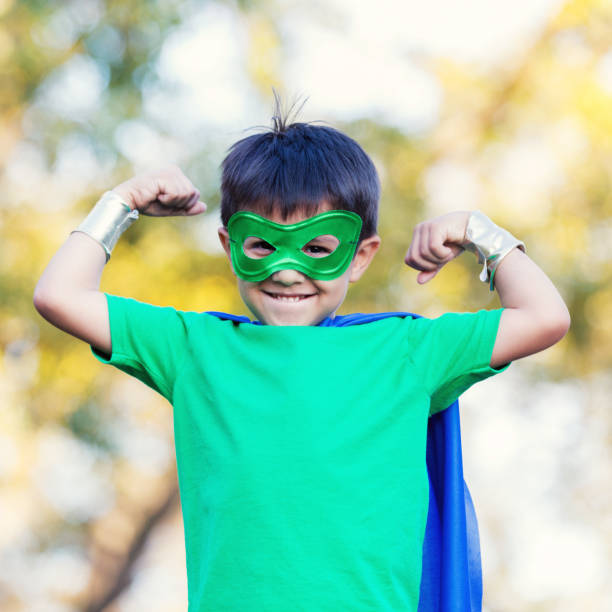 istock Little boy in superhero costume flexes muscles for camera 896216676