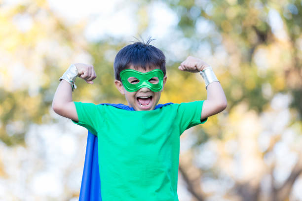 istock Little boy in superhero costume shows his strength 896216698