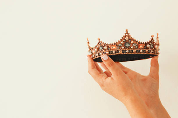 istock Woman's hand holding a crown for show victory or winning first place. White background. Copy space. Isolated. 896220986