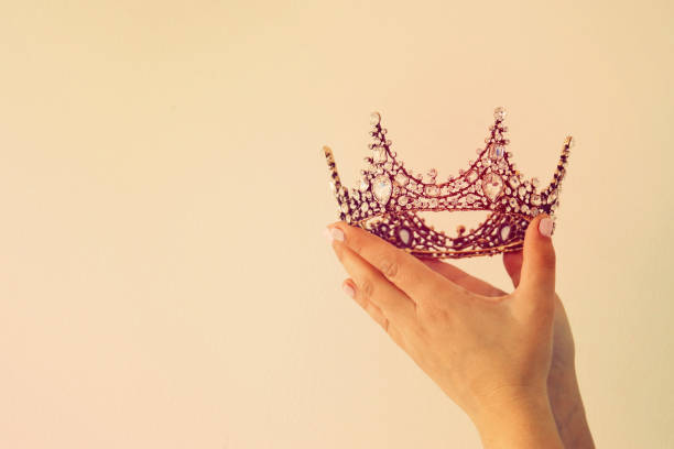 istock Woman's hand holding a crown for show victory or winning first place. White background. Copy space. Isolated. 896221022
