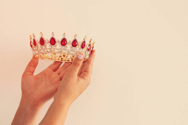 istock Woman's hand holding a crown for show victory or winning first place. White background. Copy space. Isolated. 896221854