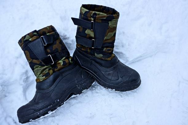 istock a pair of old boots on white snow 896229432
