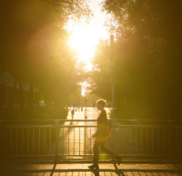 Stockholm, Sweden - September 25, 2017: Sunset scene. Woman walking on bridge in sunset in profile. Scene from central Stockholm \
