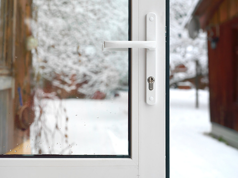 Open door in the front and a garden covered with snow, outdoor cropped photo