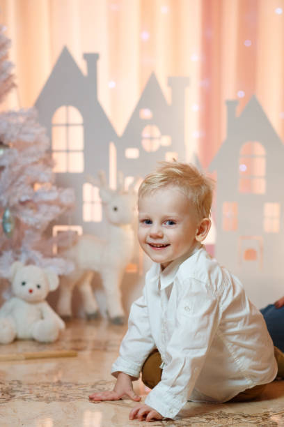 ブロンドの髪がかわいいクリスマス グッズ紙の近くに小さな少年の家 - gift little boys people blond hair ストックフォトと画像