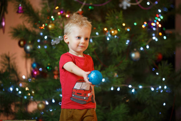 かわいい金髪のクリスマス ツリーの近くに小さな少年 - gift little boys people blond hair ストックフォトと画像