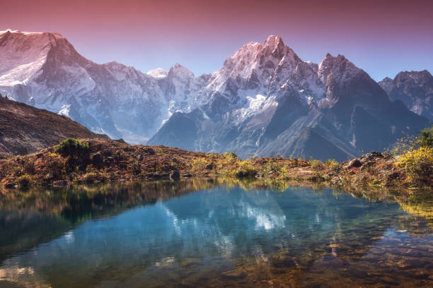 Beautiful landscape with high mountains with snow covered peaks, sky reflected in lake. Mountain valley with reflection in water in sunrise. Nepal. Amazing scene with Himalayan mountains. Nature Beautiful landscape with high mountains with snow covered peaks, sky reflected in lake. Mountain valley with reflection in water in sunrise. Nepal. Amazing scene with Himalayan mountains. Nature himalayas stock pictures, royalty-free photos & images