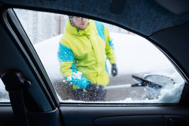 istock man clean car of snow 896250526