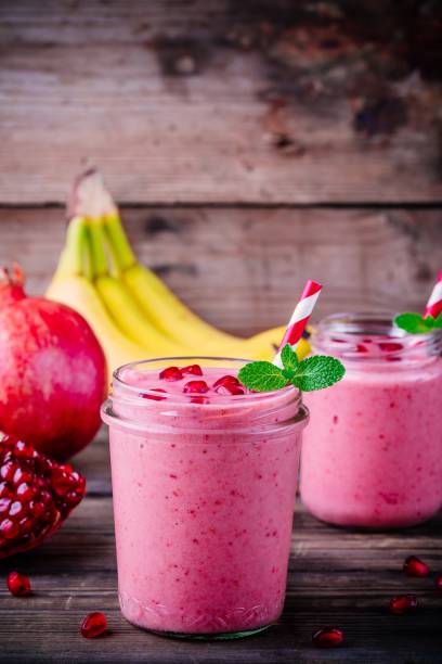 frullato di melograno rosa in un barattolo di vetro con menta e semi freschi - healthy lifestyle cranberry healthy eating milk shake foto e immagini stock