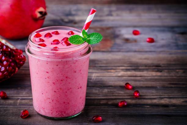 istock Pink pomegranate smoothie in a glass jar with mint and fresh seeds 896263256