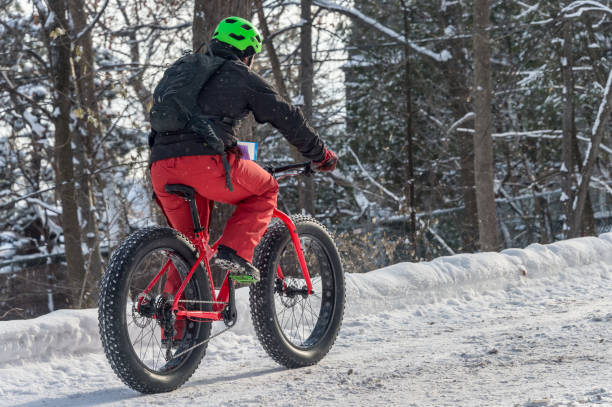 ein mann reitet einen fetten reifen snowbike im mont royal park. - snow park road cold stock-fotos und bilder