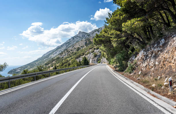 istock Country road through the rocky mountains and forest 896270110