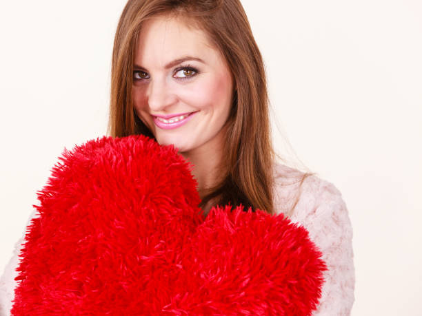 istock Happy woman holding heart shaped pillow 896288196
