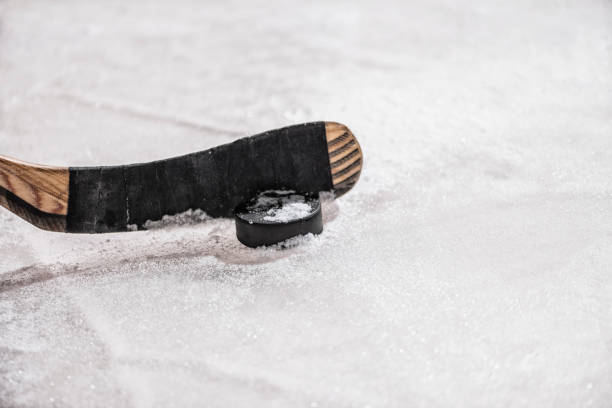 istock Ice hockey stick with puck on rough ice 896288278