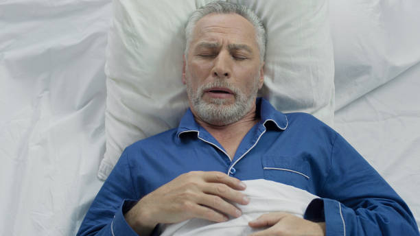 istock Aged male loudly snoring and puffing in bed, sleeping problems at old age 896291588