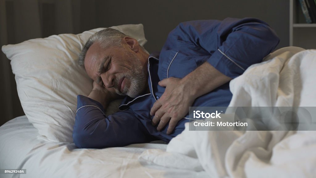 Male pensioner having heart attack, suffering sharp chest pain while sleeping Male pensioner having heart attack, suffering sharp chest pain while sleeping, stock footage Sleeping Stock Photo