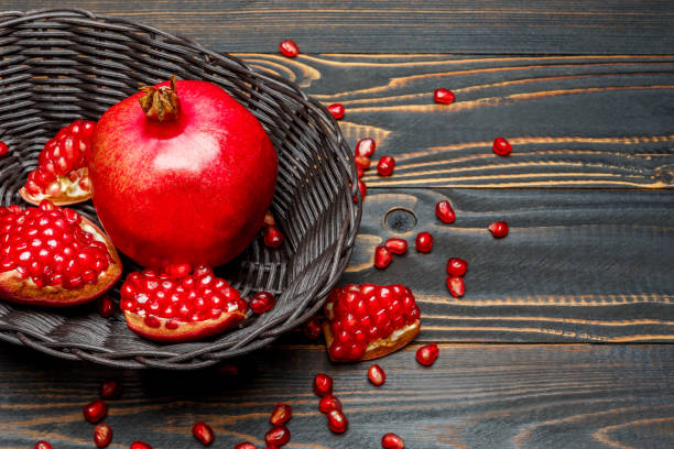 istock Pomegranate and seeds close-up on wooden background 896298544
