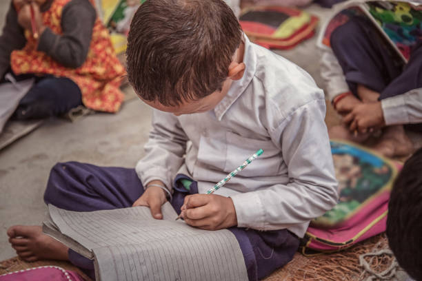 istock Concentrated Rural school kid studying on floor and writing in the notebook. 896306908
