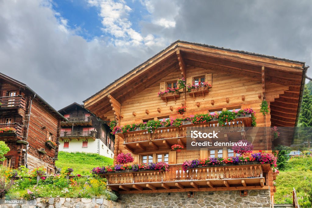 Chalet with geraniums in Grimentz Beautiful traditional wooden houses in the alpine village Grimentz, Switzerland, in the canton Valais, municipality Anniviers, with geranium flowers on the balconies Switzerland Stock Photo