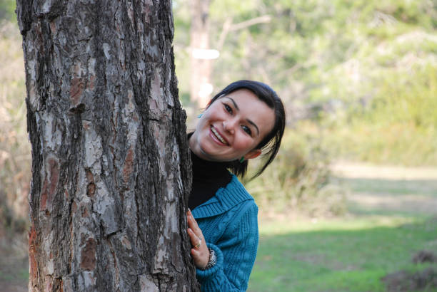 istock Cheerful young woman embracing a tree in the forest 896324290