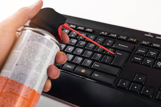 cleaning dust from computer keyboard with air pressure cleaner