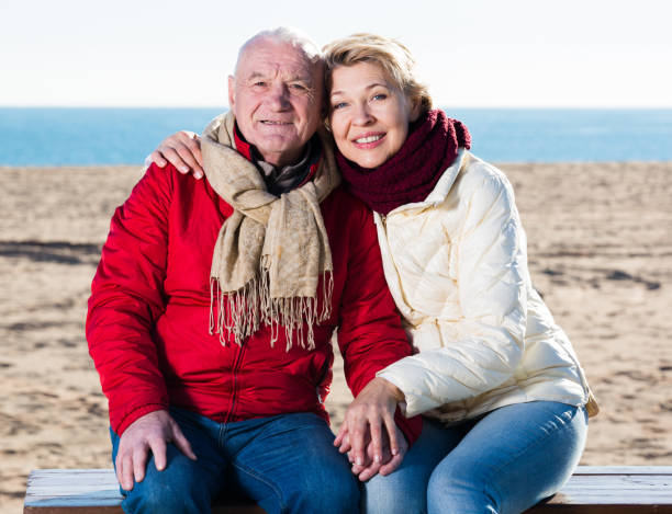 istock Mature couple sitting by sea 896333132