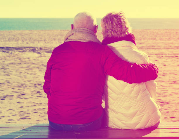 istock Mature couple sitting by sea 896333146