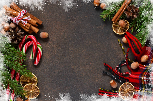istock Christmas tree with cinnamon, nuts, candy on a brown background with space under the text. 896345910