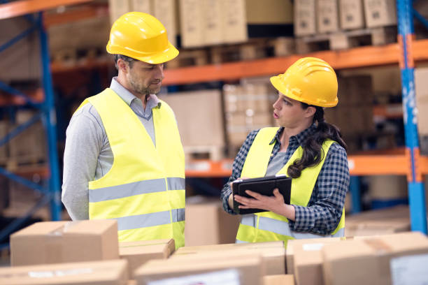 istock Female warehouse workers showing colleague notes on digital tablet 896349334