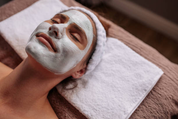 Woman with cosmetic face mask in spa Close up of woman with cosmetic mask on her face at beauty spa face cream stock pictures, royalty-free photos & images