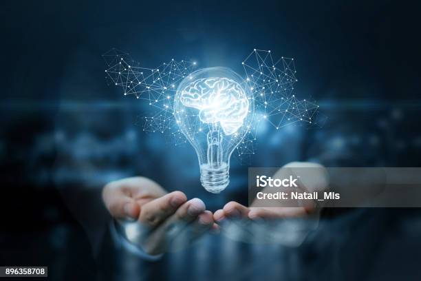 Light Bulb With Brain Inside The Hands Of The Businessman Stock Photo - Download Image Now