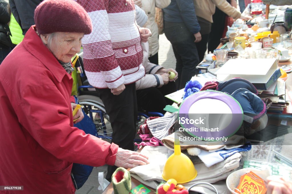 Flea market Moscow, Russia - April 29, 2016: Flea market. Elderly woman elements of stuff on the flea market. Garage Sale Stock Photo