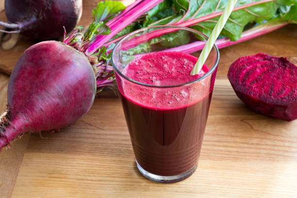 istock Red beet juice in a glass on a wooden table, with fresh beets 896375140