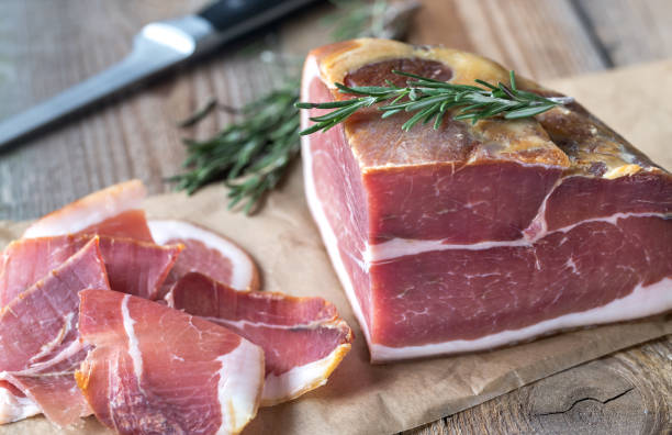 istock Prosciutto with fresh rosemary on the wooden board 896378296