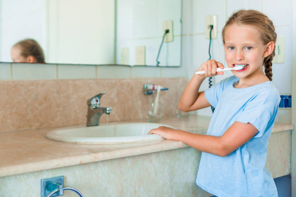 istock Little smile girl brushes teeth in the bathroom 896392364