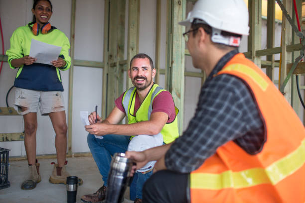 Australian mixed race workers on building site taking notes taking notes over coffee break construction lunch break stock pictures, royalty-free photos & images