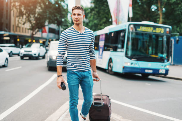 homem com mala esperando por transportes públicos - bus public transportation sydney australia australia - fotografias e filmes do acervo