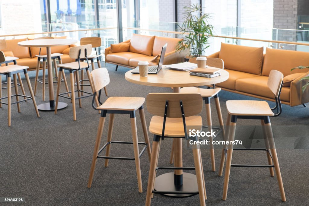 Salle de réunion dans un bureau de coworking créatrice modernes d’espace avec ordinateur portable et des tasses de café à emporter sur bar table plus maigre. Aucun peuple, moderne bâtiment intérieur. - Photo de Bureau - Lieu de travail libre de droits