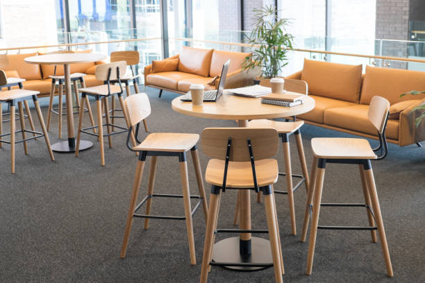 istock Meeting area in a modern creative coworking office space with laptop computer and takeaway coffee cups on bar leaner table. No people, modern building interior. 896403198