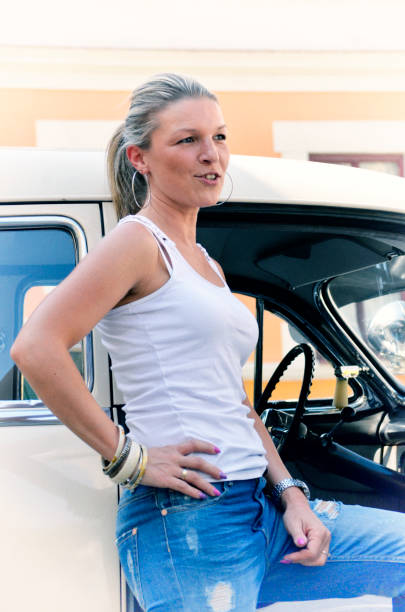the girl stands next to her old car