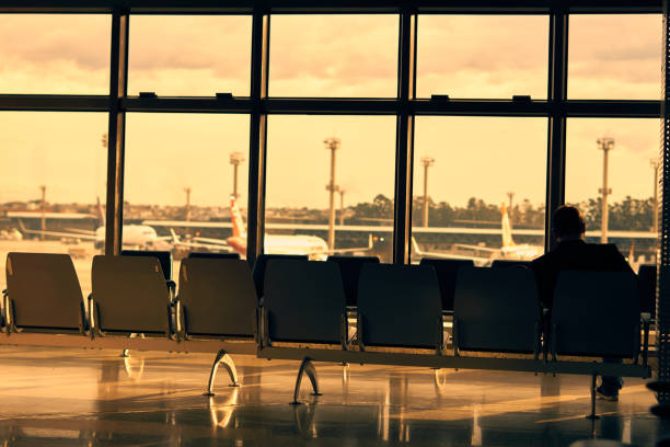 Man sitting alone on the bench inside the lobby of Guarulhos International Airport. stock photo