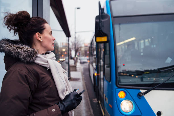 Woman getting ready to step on bus cummuting in winter.